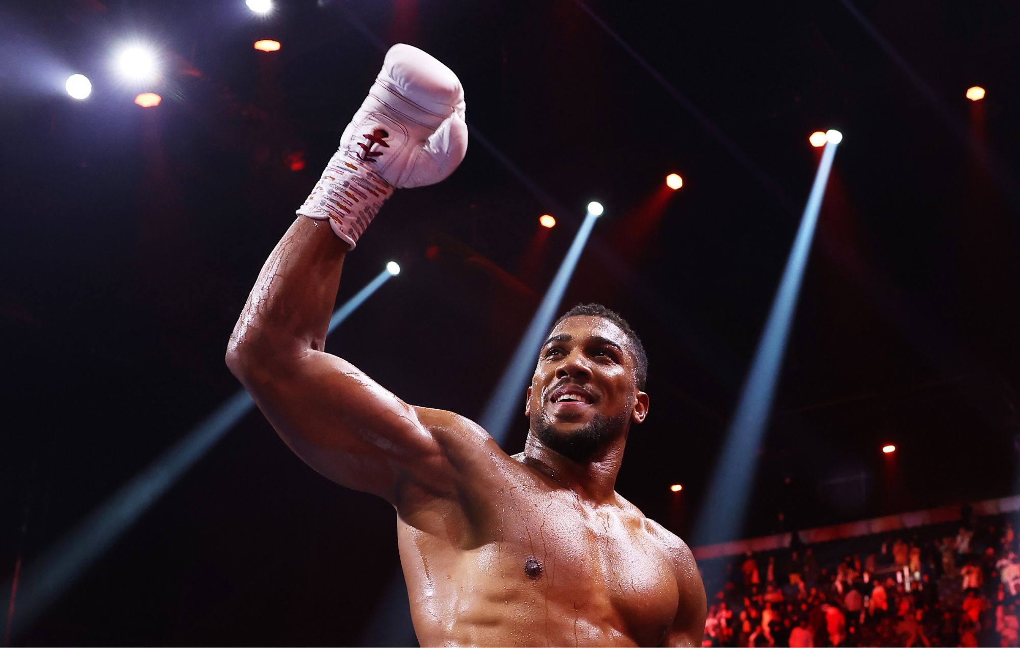 Anthony Joshua point levé sur un ring de boxe