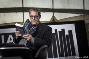 L'écrivain Paul Auster tenant son livre à la main